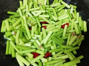 锅底留余油烧热，下入干红辣椒爆香，下入蒜苔翻炒至变色。