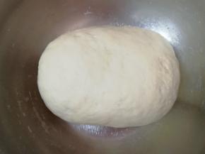 分次加入温水和成软硬适宜的面团，盖上保鲜膜发酵至两倍大。