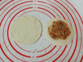 擀成中间稍厚边缘薄的包子皮，放上牛肉馅。