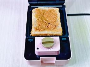 烤盘上再刷薄薄一层食用油，先放上一片吐司片，涂抹上花生酱。