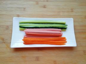 黄瓜和胡萝卜洗干净，火腿肠去掉外包装，分别切成条状。