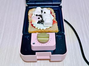 摆放上棉花糖，巧克力豆，叠加上一片吐司，盖上机器盖子，2分钟就可以。