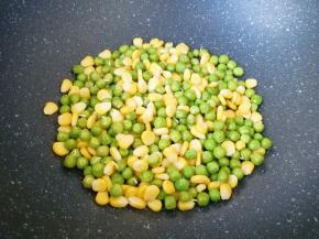 炒锅内倒适量的食用油烧热，下入焯过的豌豆和玉米粒翻炒均匀。