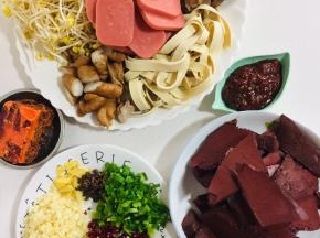 首先准备好这道菜所需要的食材：

猪血切成块儿，黄豆芽洗净，千张切成条状，卤肥肠切成段，毛肚切条，芹菜切成段，火腿肠切成片，蒜瓣切成末，葱切成葱花，干辣椒切成段，准备好一块火锅底料，花椒和一勺郫县豆瓣酱备用！

