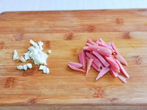 大蒜去皮切碎，香肠切条。