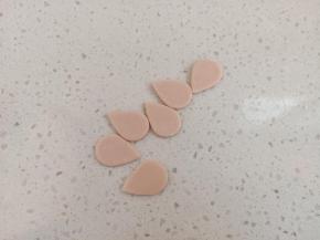 粉色面团也重新排气，擀薄，切同样的水滴形，要比白色的小一些