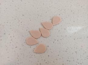 粉色面团也重新排气，擀薄，切同样的水滴形，要比白色的小一些