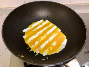 然后在煎蛋清的空隙中倒入鸡蛋黄，继续小火煎熟，煎好了盛起备用。同样的方法再煎一小块，摆盘的时候用。