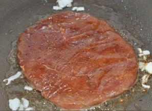 4 将牛排放入锅中