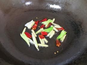 炒锅内倒适量的调和油烧热，下入蒜苗、姜丝和干红辣椒炒香。