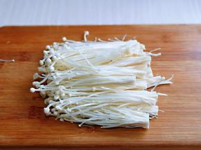 首先将金针菇去根，冲洗干净。