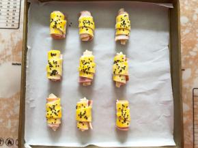 摆入烤盘，刷上蛋黄液，撒上黑芝麻