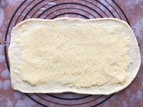 发酵好的面团分成4等份，盖上保鲜膜松弛15分钟，擀成长方形，铺上椰蓉