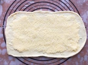 发酵好的面团分成4等份，盖上保鲜膜松弛15分钟，擀成长方形，铺上椰蓉