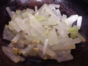 锅中倒入油加热放入蒜粒爆香再放入冬瓜条翻炒