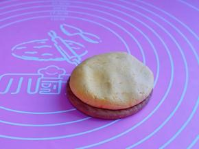 取一块饼干，南瓜面团用掌心轻轻压扁，放在饼干上，压制与饼干同样大小即可。