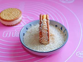 最后裹上白芝麻，再用手轻轻拍掉多余的芝麻，南瓜面团上的芝麻捏捏紧。