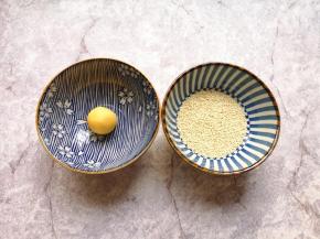 准备两个小碗，一个小碗底放上一点点水，一个小碗里放上熟白芝麻，先把南瓜糯米球放进有水的小碗里沾上水。