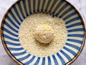 再放进芝麻碗里滚一下粘上白芝麻。