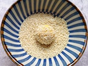再放进芝麻碗里滚一下粘上白芝麻。
