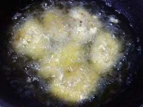 锅中倒入适量油加热至油温7-8成热放入鸡翅开始炸