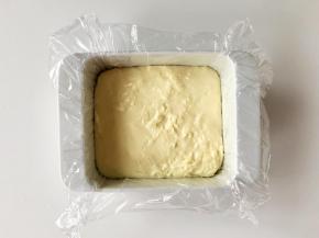 取一个方形模具，铺上保鲜膜，方便脱模。把熬好的奶糊倒进去，刮平。