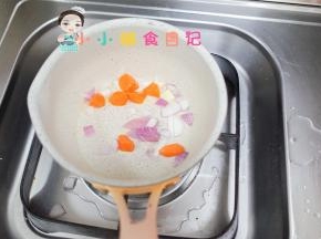 锅里加一点油加入胡萝卜跟洋葱翻炒，洋葱炒了之后是甜的而且香味浓郁一定不能少