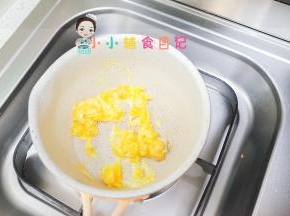 锅里加一点点油放入鸡蛋炒散，油不能多因为多了也不容易把饭团粘合牢固