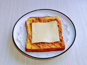 再放上一片奶酪，把另一片吐司叠加上，轻轻压一下。