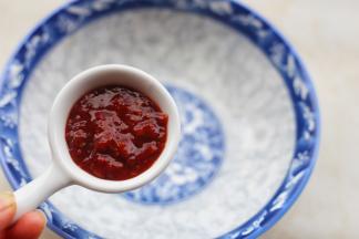 大碗中加两勺辣椒酱。