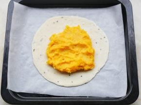 将红薯泥均匀铺在手抓饼上。