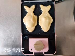 在豆沙上挤入面糊，要完全盖住豆沙，面糊会流到鱼鳍位置，如果鱼鳍位置不满就挤入一点面糊填满，最后将鱼尾部位填满。