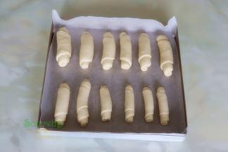 烤盘垫上硅油纸，把卷好的面包胚，均匀放入烤盘。放入烤箱，按发酵，时间45分钟，烤箱需要放一盘温水，保持烤箱的湿度。