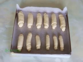 烤盘垫上硅油纸，把卷好的面包胚，均匀放入烤盘。放入烤箱，按发酵，时间45分钟，烤箱需要放一盘温水，保持烤箱的湿度。