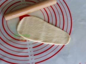 取一块小团，揉搓成一头粗一头尖的形状，用擀面杖擀成三角形。