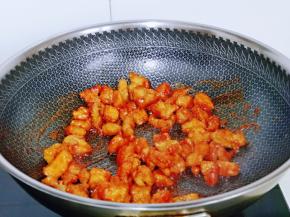 下入炸好的鸡块，快速翻炒，使每块鸡肉都裹上番茄酱汁。