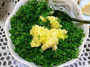 将搅拌好的蒜蓉与法香末、室温软化后的黄油一起，搅拌均匀。