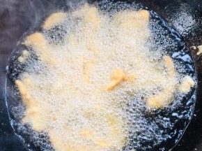 油温升高开始冒烟了，放入腌制好的鸡柳大火炸！记得要一个一个的放入，以防粘在一起！