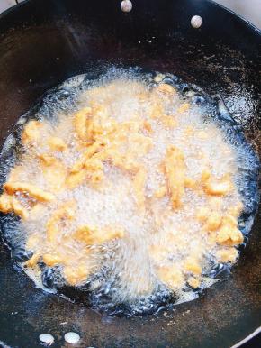 炸好的鸡柳全部下锅复炸一分钟，捞出沥干油分备用！