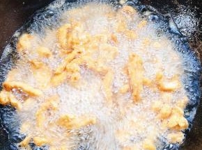 炸好的鸡柳全部下锅复炸一分钟，捞出沥干油分备用！