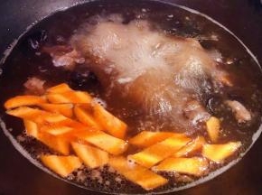 胡萝卜切片和泡发好的木耳以及调味料蚝油、一品鲜酱油、糖放入汤中烧开