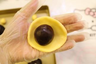 饼皮压平，包上内陷，收口捏紧。