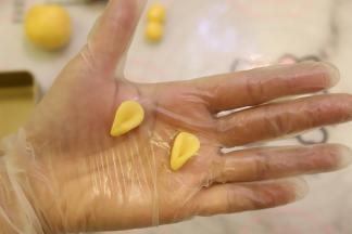 1克的饼皮分别搓圆，压成小圆，捏成小耳朵。