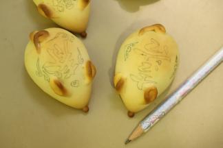 用食用铅笔在小老鼠的背面上画好喜庆的图案。