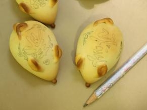 用食用铅笔在小老鼠的背面上画好喜庆的图案。