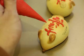 糖霜或者融化的巧克力调成红色，装入裱花袋，填好图案的颜色。