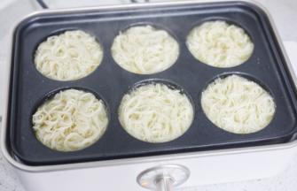 将面条放入，煎至一面定型后翻煎另一面，两面煎至金黄。