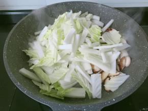 下白菜帮大火翻炒，翻炒至包菜断生。
