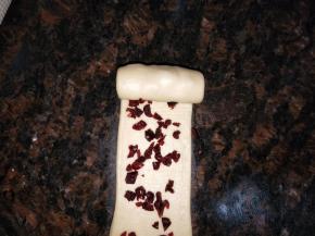 第二卷。从第一个面团开始，光滑的一面朝底，在面团的延伸下擀至最大，大约30cm长。从上往下卷起每卷一圈往上面推一推，卷实