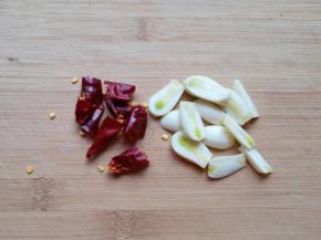 大蒜切成片，干红辣椒掰成两半。